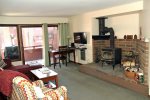Mammoth Condo Rental Wildrose 9: Living room with wood burning stove and access to outdoor deck